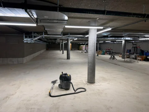 Grosser Innenbereich während der Bauphase mit bereitstehendem Industriesauger.