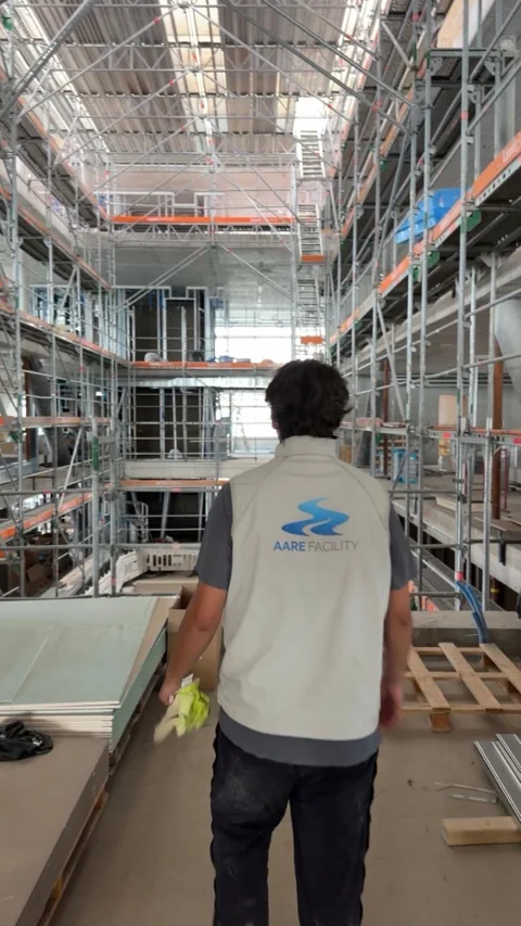 Mitarbeiter von Aare Facility in einer grossen Baustellenhalle.